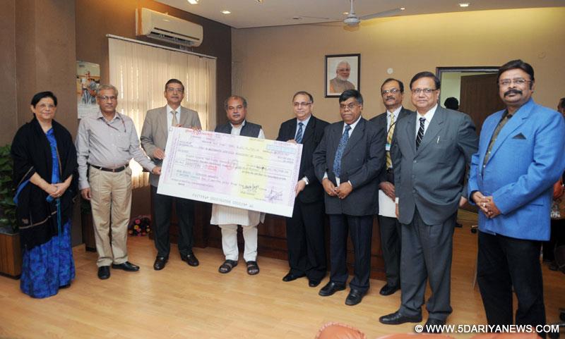Narendra Singh Tomar receiving the dividend cheque from the CMD of MECON, Shri A.K. Tyagi, in New Delhi on November 13, 2014