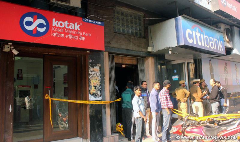 Delhi Police personnel investigating after robbers looted a cash van outside Citi Bank`s ATM in Kamla Nagar area in Delhi on Nov. 29, 2014