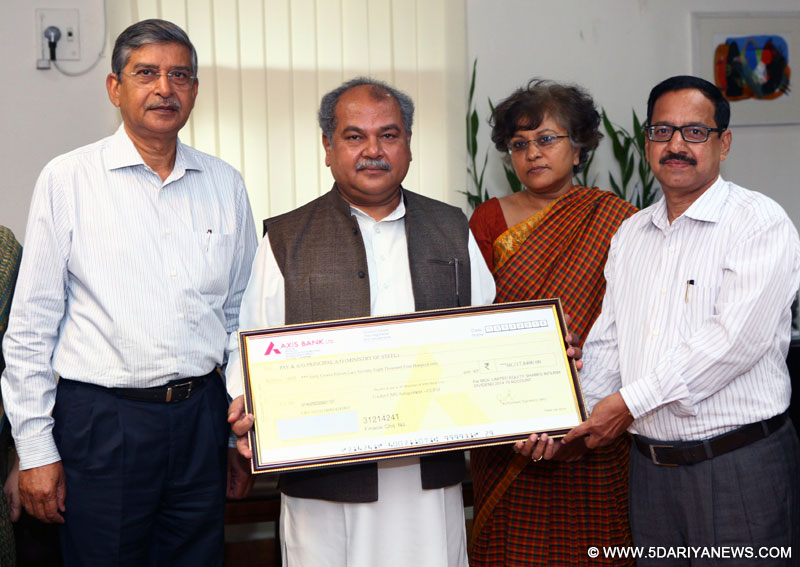 The Union Minister for Mines and Steel,  Narendra Singh Tomar being presented a dividend cheque by the CMD, MOIL, G.P. Kundargi, in New Delhi on April 13, 2015.