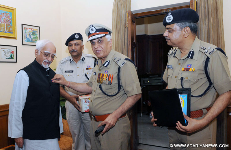 The Director-Delhi Fire Services, A.K. Sharma pinning a flag on the Vice President, Mohd. Hamid Ansari, on the occasion of the Delhi Fire Service Week, in New Delhi on April 16, 2015.