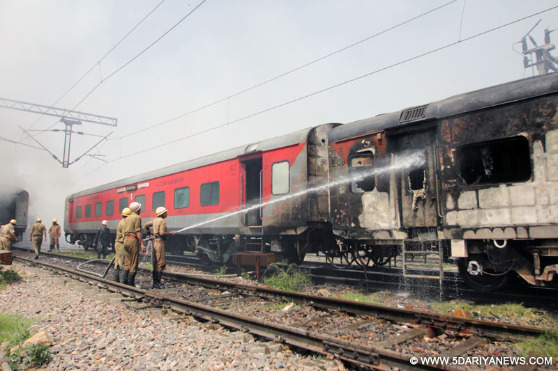New Delhi: Firefighters douse the fire that broke out in a Bhubaneswar-New Delhi Rajdhani Express train at the New Delhi railway station yard, on April 21, 2015. At least five coaches of the train were damaged. 