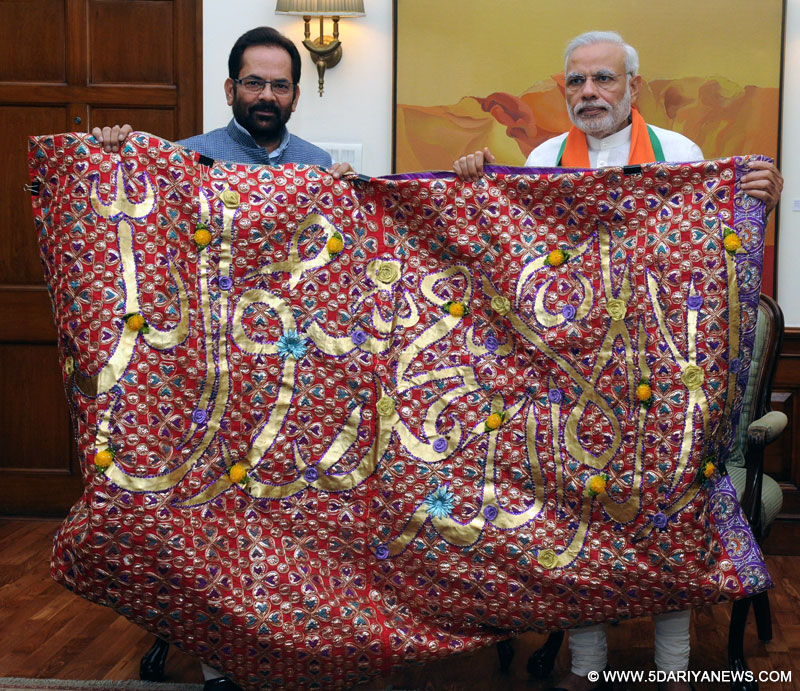 The Prime Minister, Narendra Modi handing over the "Chaadar" to be offered at Dargah of Khwaja Moinuddin Chishti, Ajmer Sharif, to the Minister of State for Minority Affairs and Parliamentary Affairs, Mukhtar Abbas Naqvi, in New Delhi on April 21, 2015.
