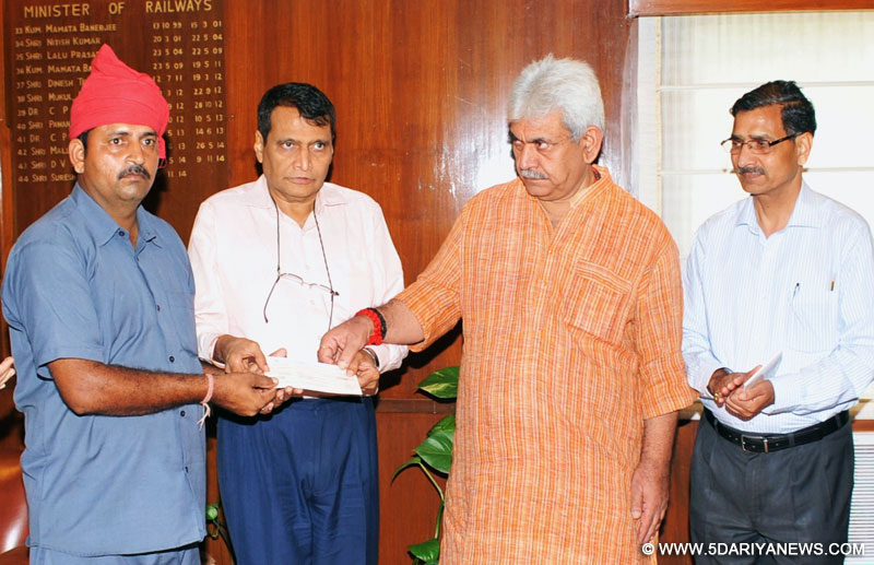 The Union Minister for Railways, Shri Suresh Prabhakar Prabhu and the Minister of State for Railways, Shri Manoj Sinha felicitating the Railway employee Shri Ashwani Kumar, Firozpur Division, for showing courage in detecting suspected bomb type object on Railway Bridge, at a function, in New Delhi on August 19, 2015. The Chairman, Railway Board, Shri A.K. Mital is also seen.