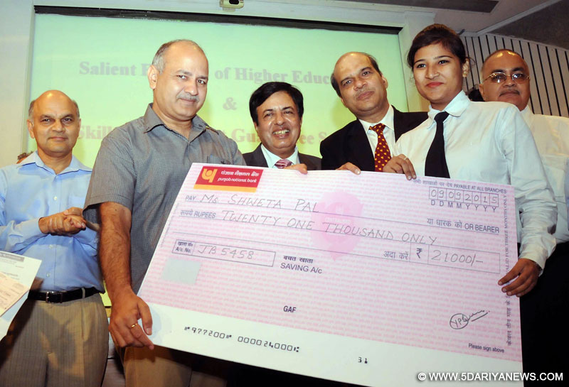 Delhi Deputy Chief Minister Manish Sisodia hands over a cheque to a student during a programme organised to launch Delhi Government