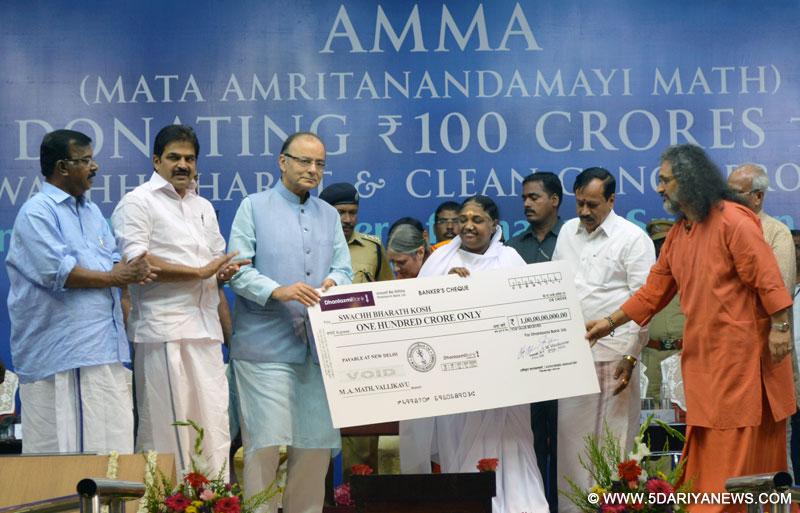Arun Jaitley receiving a cheque of Rs.100 crore for the Swachh Bharat and Namami Gange projects from the spiritual leader Mata Amritanandmayi, at Amritapuri, Vallikkavu, in Kollam, Kerala on September 11, 2015. The Former Union Minister, Shri O. Rajagopal and Shri K.C.Venugopal, MP are also seen.