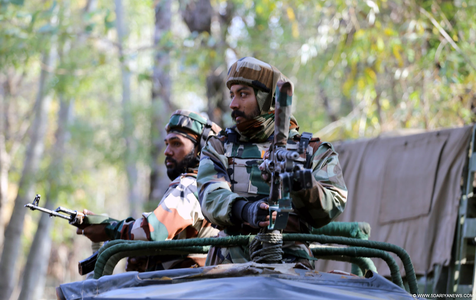 Soldiers take position during an encounter with militants in Bongam village of Jammu and Kashmir