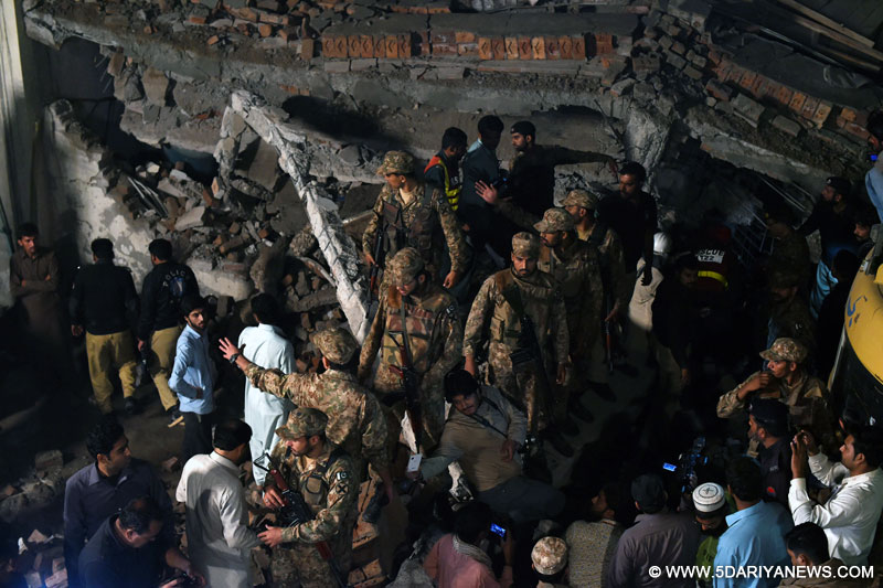 Pakistani soldiers search for victims in the rubble of a collapsed factory in eastern Pakistan