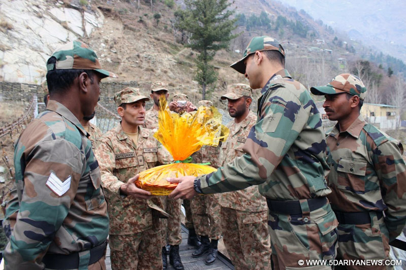  Indian and Pakistani army officials exchange sweets on Republic Day at Kaman Post in Kupwara district of Jammu and Kashmir on Jan 26, 2016. 