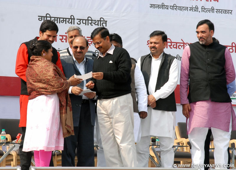 Delhi Chief Minister Arvind Kejriwal hands over subsidy cheques to e-rickshaw owners at Chhatrasal stadium in New Delhi, on Feb 17, 2016. Also seen Delhi Transport Minister Gopal Rai. 