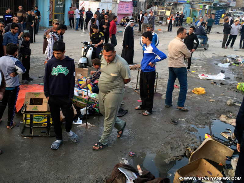 People gather at the site of a suicide bombing attack in the Iraqi capital of Baghdad