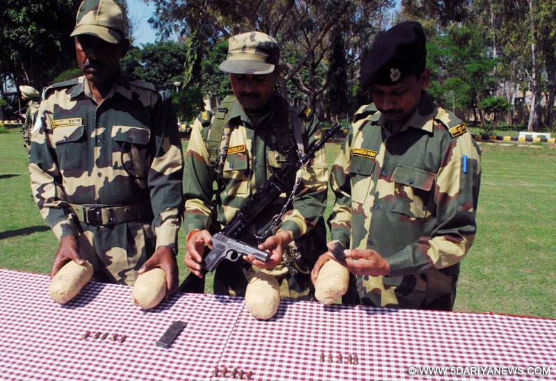 BSF personnel present before press four packets of heroin and arms recovered from smugglers near Fatehpur, on March 20, 2016.