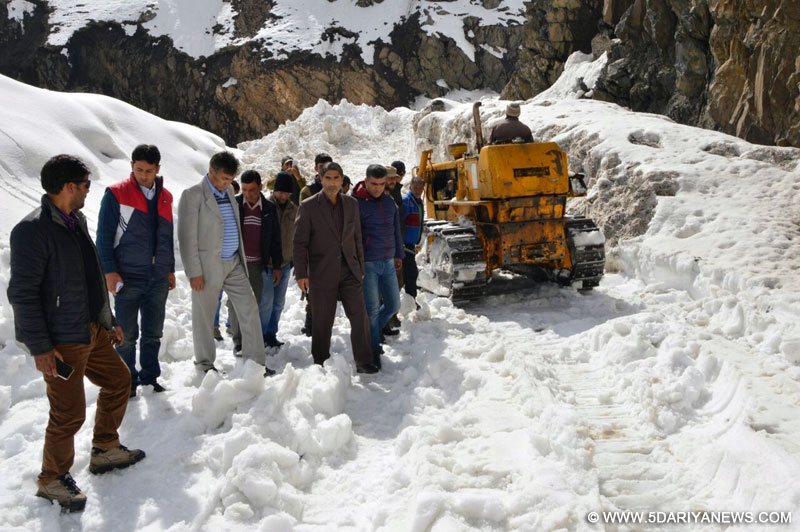 People clear snow from Mughal Road in Shopian district of Jammu and Kashmir on March 25, 2016. 