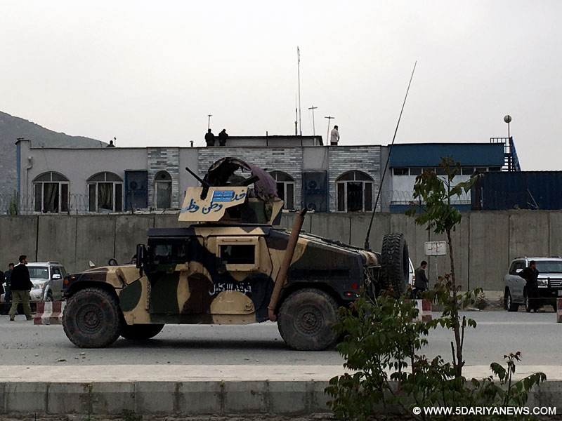 An Afghan security vehicle patrols at the attack site as the gunfight is still underway in Kabul