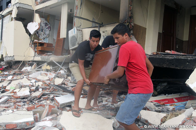 Members of a family recover the belongings of their house damaged by the earthquake in Portoviejo, Ecuador