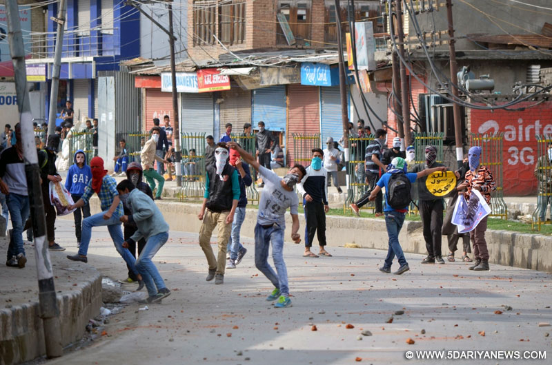 Youths pelt stones on security personnel in Srinagar on May 6, 2016. 