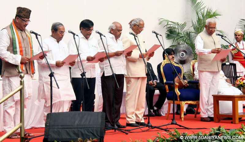 Karnataka Governor Vajubhai Vala administers oath to newly appointed Ministers (L to R) Tanveer Sait, HY Meti, Basavaraj Rayareddy, Ramesh Kumar and Kagodu Thimmappa , their swearing-in ceremony at Raj Bhavan in Bengaluru, on June 19, 2016.