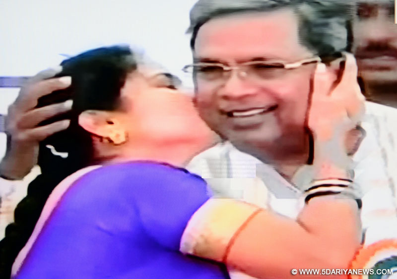 A TV grab of newly-elected Karnataka local body member Girija Srinivas planting a kiss on Karnataka CM   Siddaramaiah