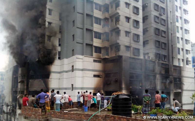 People watch heavy smoke from a fire at a residential multi-story building at Uttar Badda in Dhaka, Bangladesh, June 29, 2016.