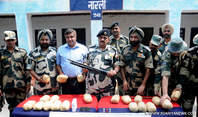 BSF officials present before press the 21 kg of heroin recovered in the Amritsar sector of the border along with an Italian-made shot-gun and Pakistan-made ammunition; on July 13, 2016. 