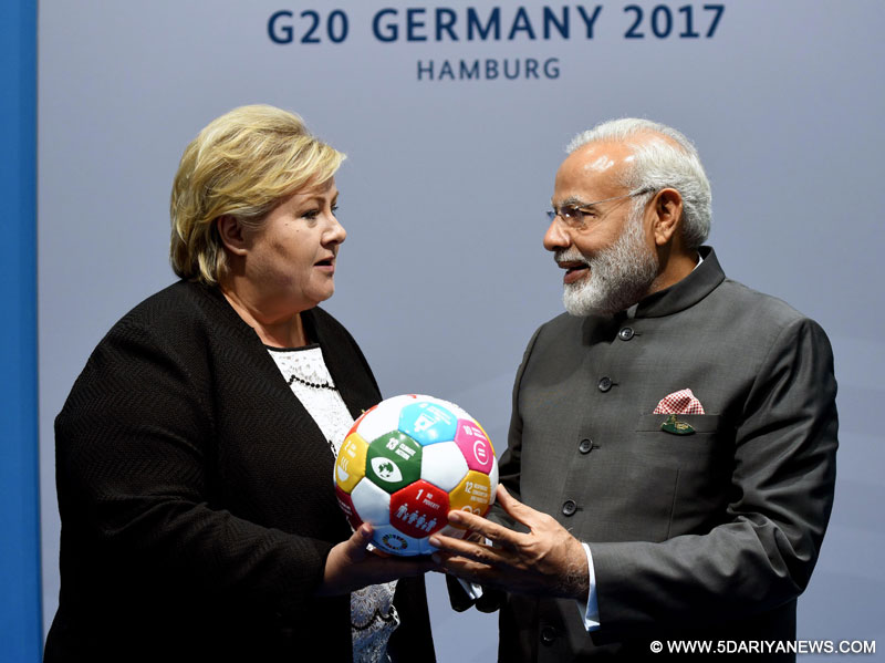 The Prime Minister of Norway, Ms. Erna Solberg presenting the symbolic football on Sustainable Development, to the Prime Minister, Shri Narendra Modi, at the 12th G-20 Summit, at Hamburg, Germany on July 08, 2017.