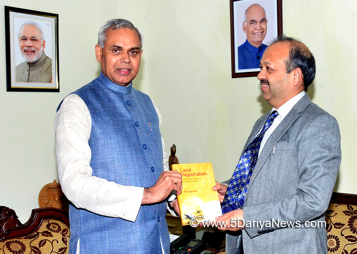 Chief Secretary presents his book to Governor Acharya Devvrat