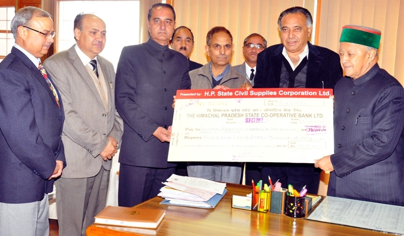 Virbhadra Singh, being presented a cheque of Rs. 35 Lakh by Food, Civil Supplies & Consumer Affairs Minister Sh. G.S. Bali in Shimla today.