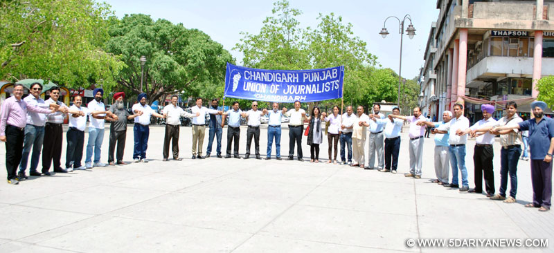 Members of the Chandigarh-Punjab Union of Journalists (CPUJ) forming a human chain by holding hands of one another on May Day Rally at Sector - 17 Plaza on Thursday at Chandigarh.