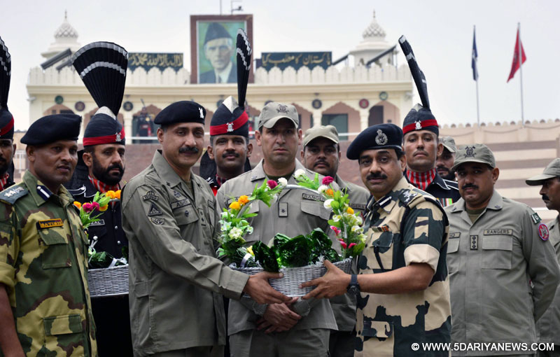 Pak Rangers officials giving sweets and fruit basket to his Indian counterparts at Attari land border on the occasion of Eid ul Fitr on July 29, 2014.