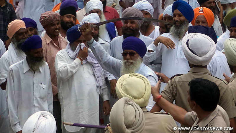Members of the newly-created Haryana Sikh Gurdwara Parbandhak Committee (HSGPC) clash with police near a gurdwara in a takeover bid in Kurukshetra on Aug 6, 2014. 