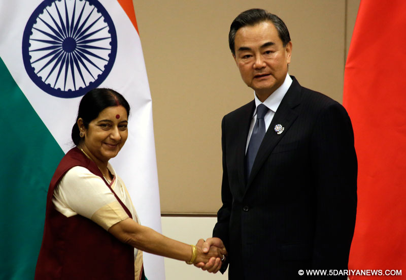 Chinese Foreign Minister Wang Yi (R) meets with Indian Foreign Minister Sushma Swaraj on the sidelines of the series of Foreign Ministers