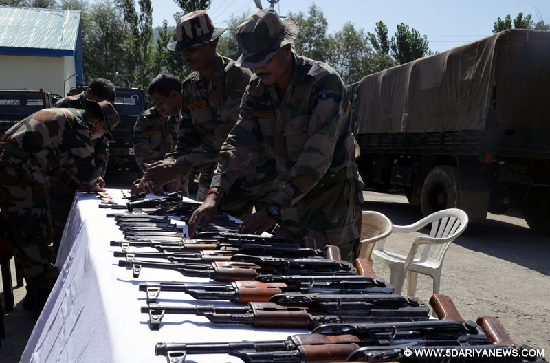 Security personnel display arms and ammunition recovered from a militant hide-out in Bandipora district of Jammu and Kashmir on Aug 21, 2014.