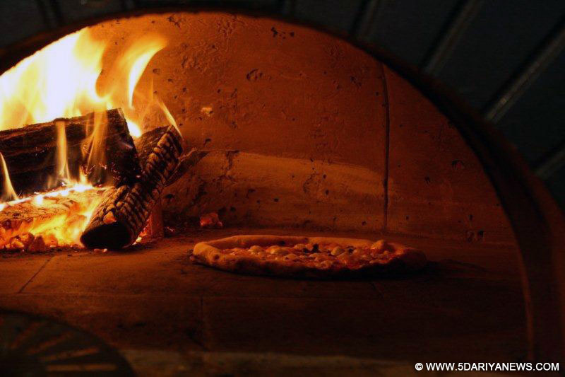 Clarkes’kitchen executive Meet Singh Malhotra bakes a pizza in Shimla.
