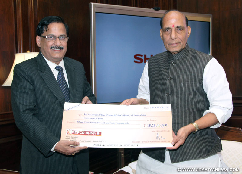 Rajnath Singh receiving a dividend cheque of Rs. 15.26 crore for the year 2012 - 13 from the Managing Director of Repatriates Cooperative Finance and Development Bank Limited 
