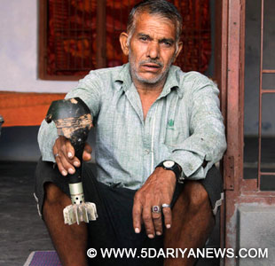 A villager shows a mortar shell that was allegedly fired from Pakistani side in Arnia of Jammu and Kashmir on Oct.13, 2014. 
