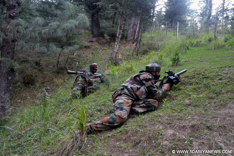 Soldiers take position during an encounter in Waderbala forests of Handwara, Jammu and Kashmir, on Oct.13, 2014.